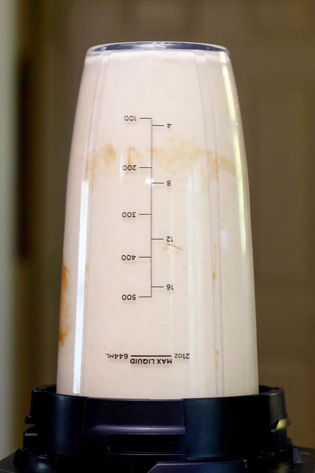 A creamy peanut butter smoothie being blended in a bullet-style blender cup.