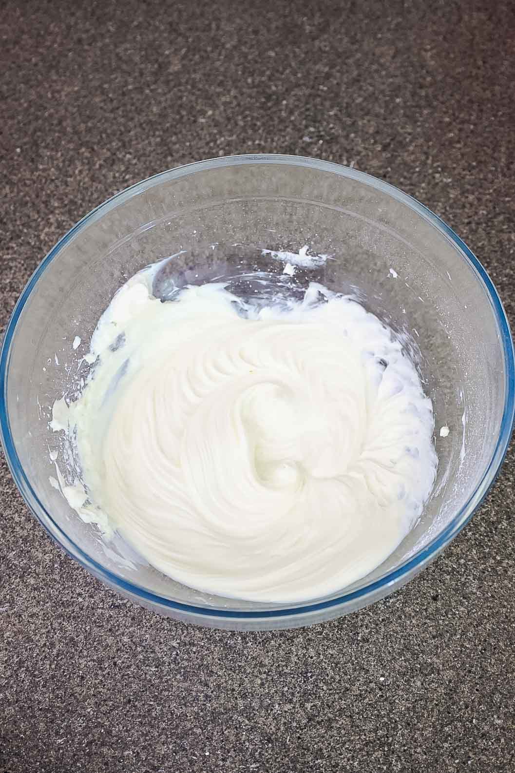 Mixture in a glass bowl after powdered sugar and vanilla are blended into whipped cream cheese.