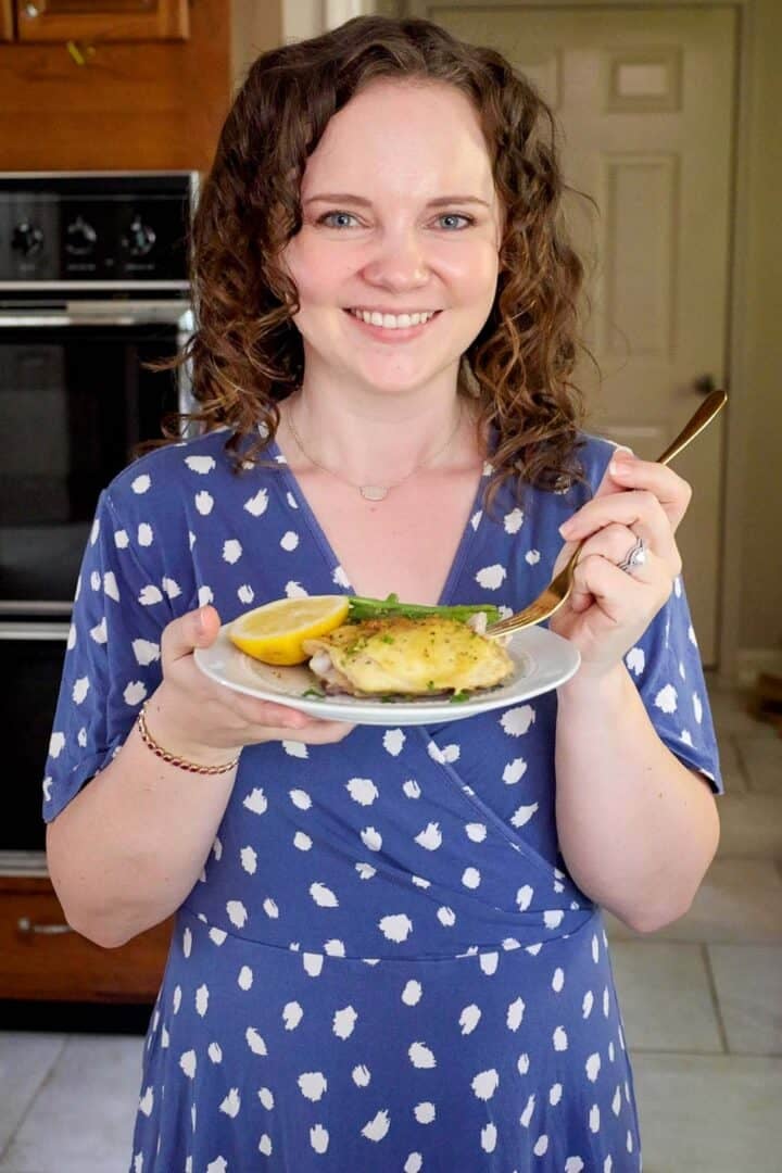 Kelsey Smith holding a plate of lemon pepper chicken thighs.