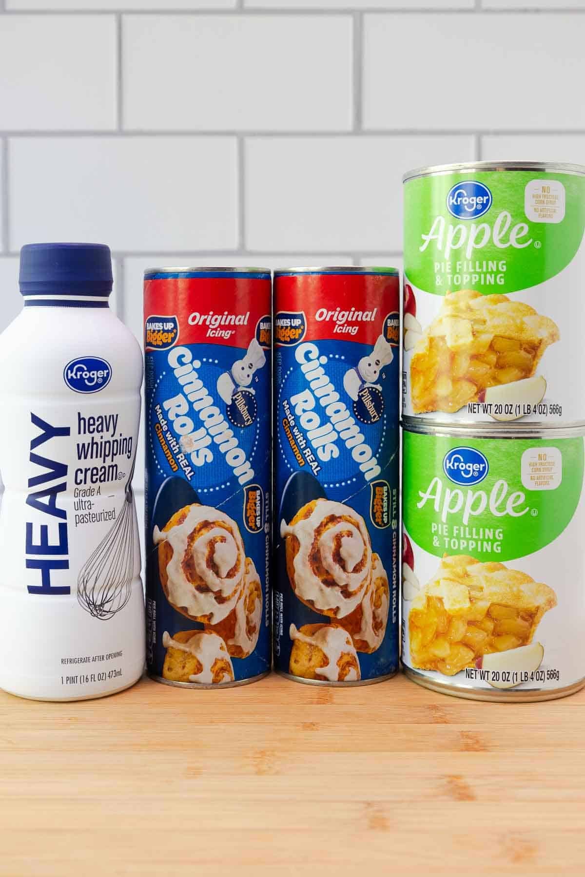 Heavy cream, two cans of Pillsbury Cinnamon Rolls, and two cans of Apple pie filling and topping.