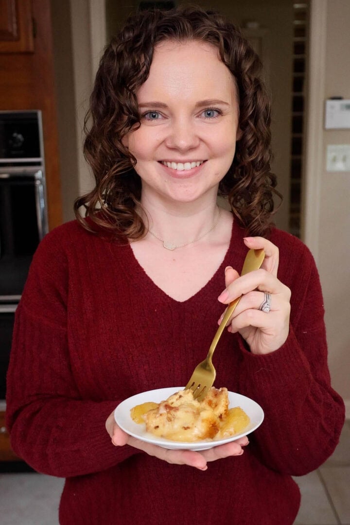 Kelsey Smith holding a small plate with an apple cinnamon roll.