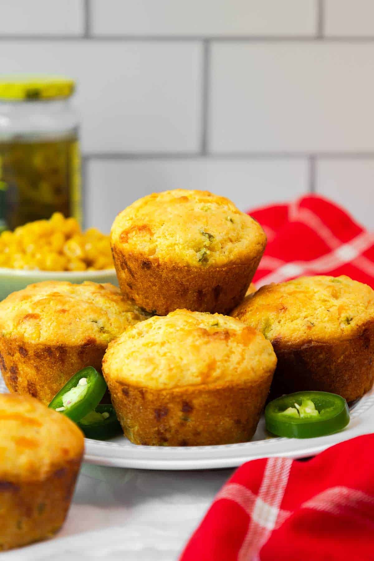 A plate filled with golden jiffy jalapeño cornbread muffins.