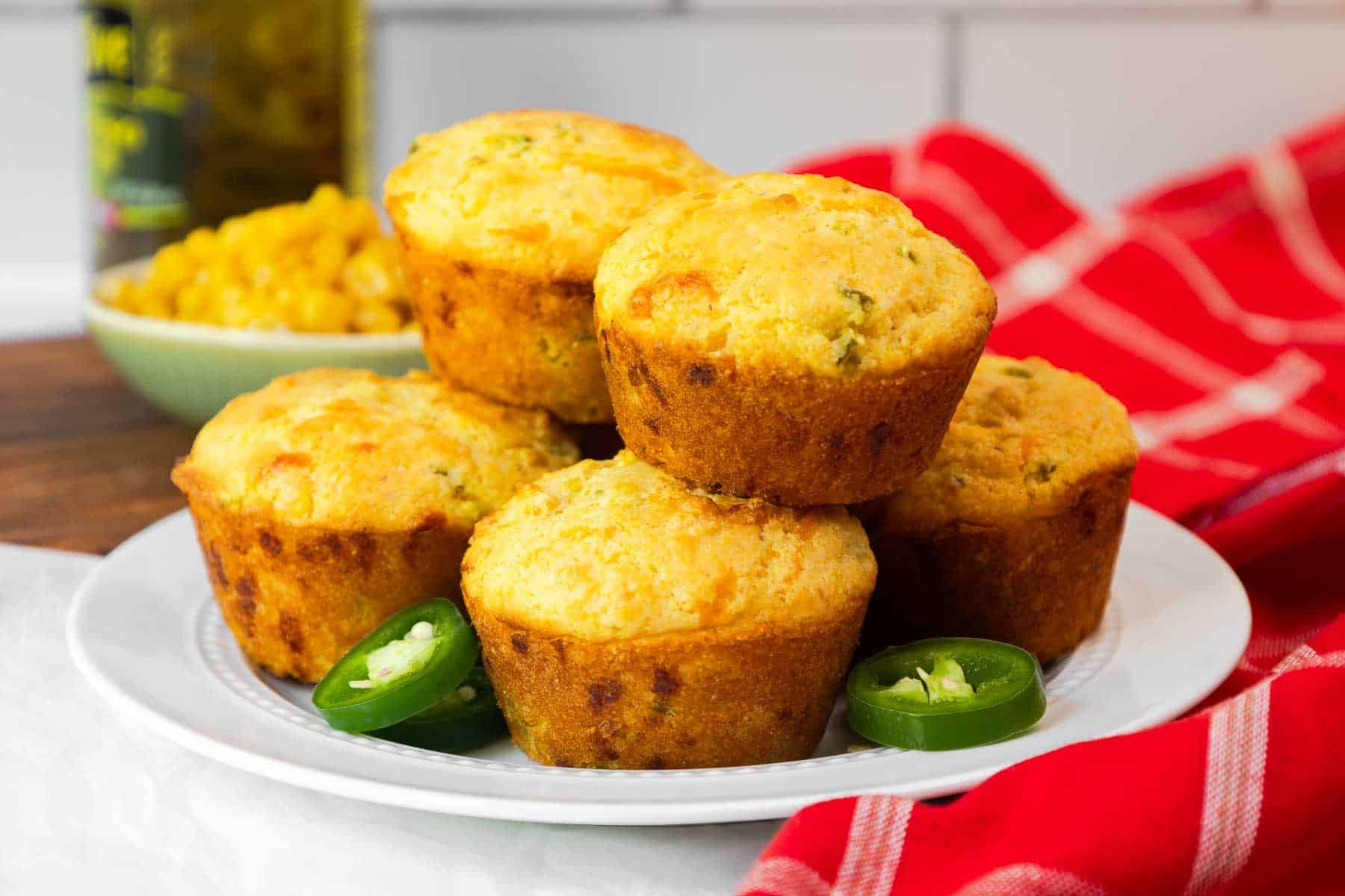 A plate filled with golden jiffy jalapeño cornbread muffins.