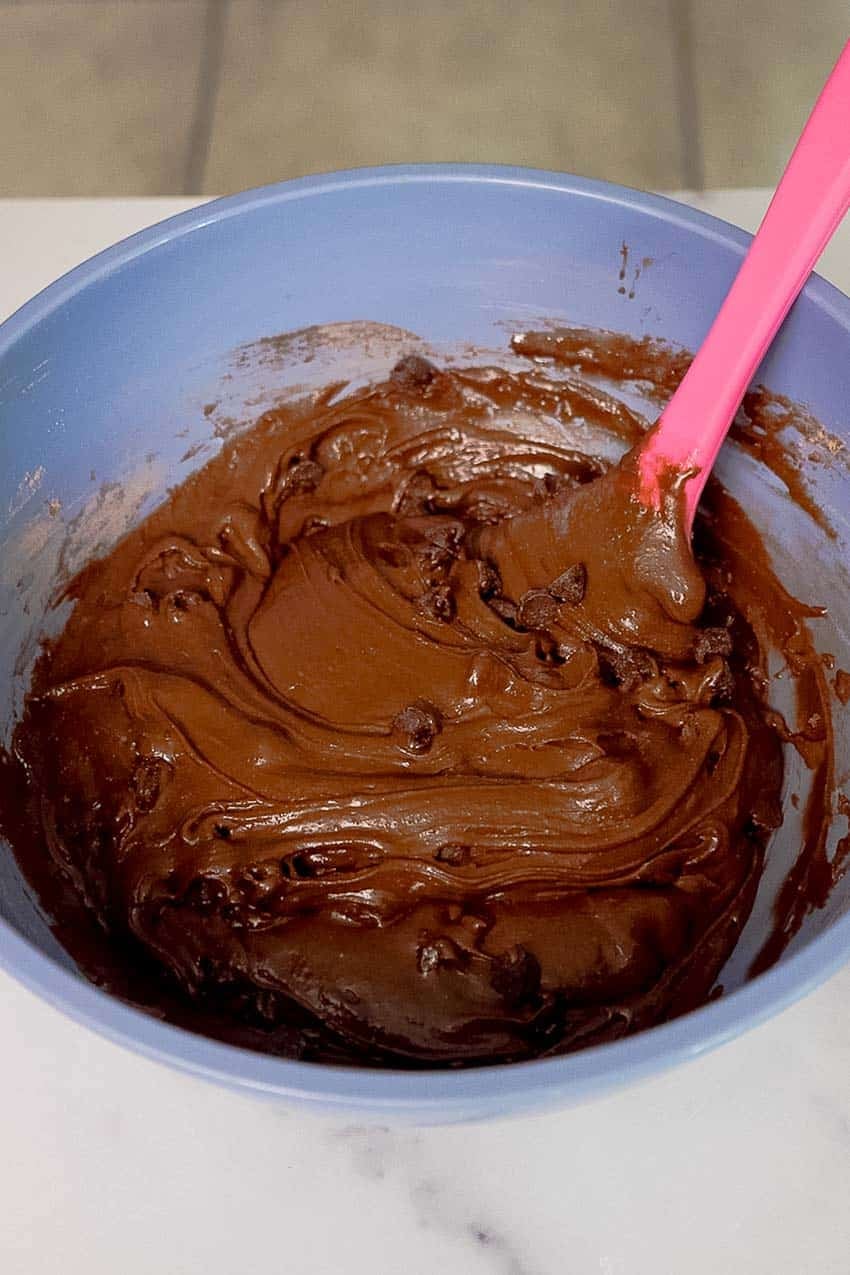 Chocolate chip brownie batter mixed and ready in a medium mixing bowl.