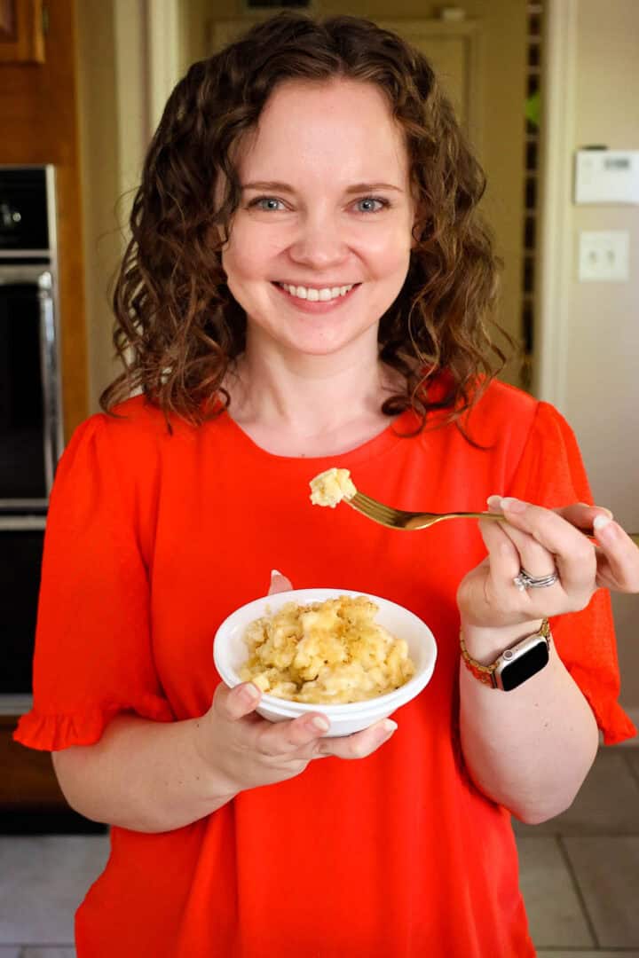 Kelsey Smith holding a bowl and fork of mac and cheese.