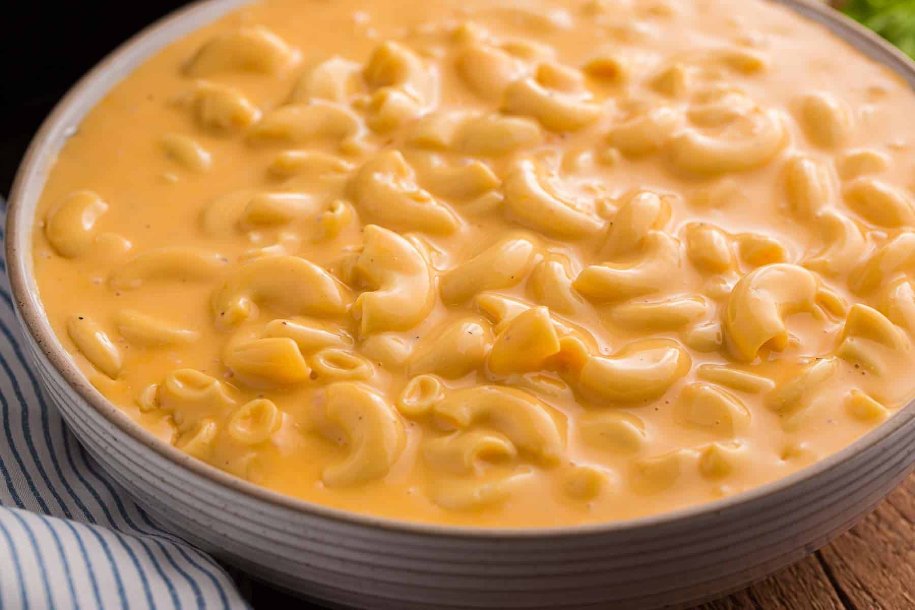 A full bowl of creamy mac and cheese with tender elbow macaroni coated in a smooth orange cheese sauce.