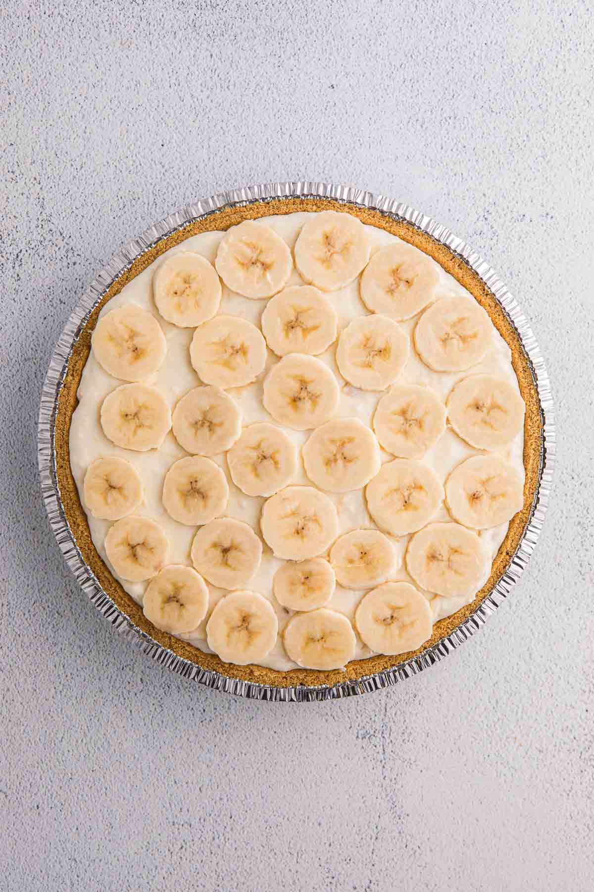 Banana slices layered over creamy filling in a graham cracker crust.
