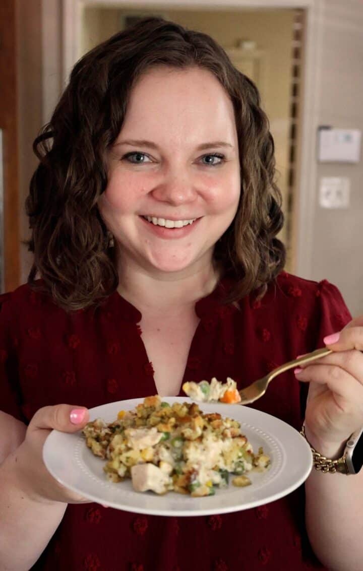 Kelsey Smith holding a plate of chicken stuffing casserole.