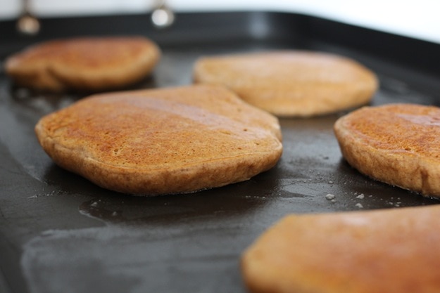 Pancakes cooking on the griddle.