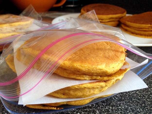 Pancakes stacked in a food storage bag with parchment paper in between each pancake.