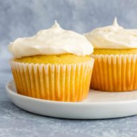 Two vanilla cupcakes topped with buttercream frosting.