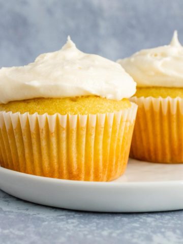 Two vanilla cupcakes topped with buttercream frosting.