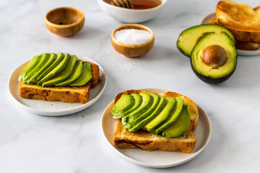 Two slices of toast with sliced avocado on top