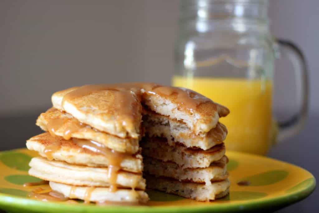 Stack of banana pancakes with a slice taken out.