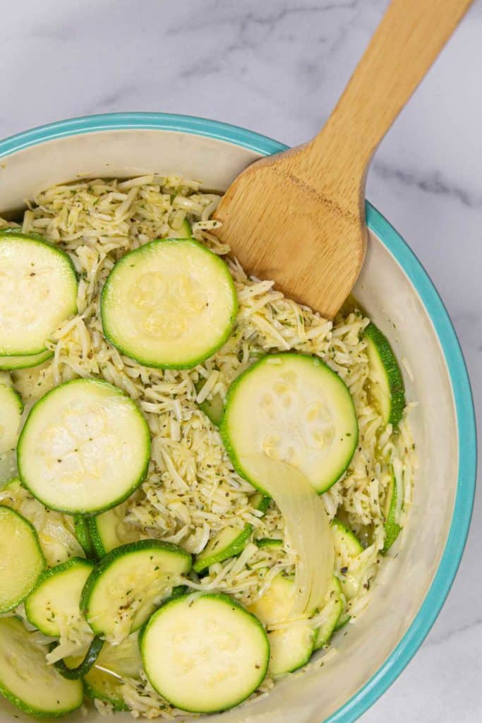 Cheesy zucchini casserole filling in a large mixing bowl.