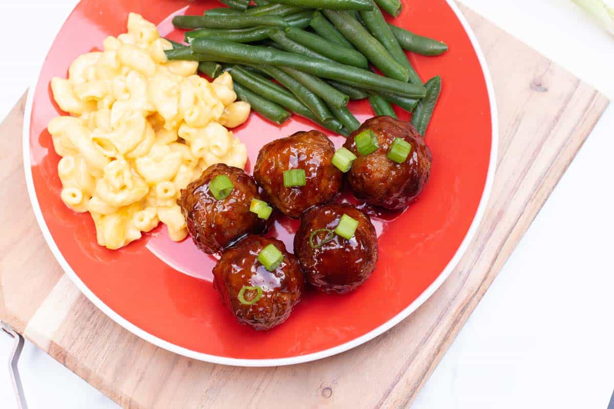Plate with BBQ meatballs, green beans, and macaroni and cheese.