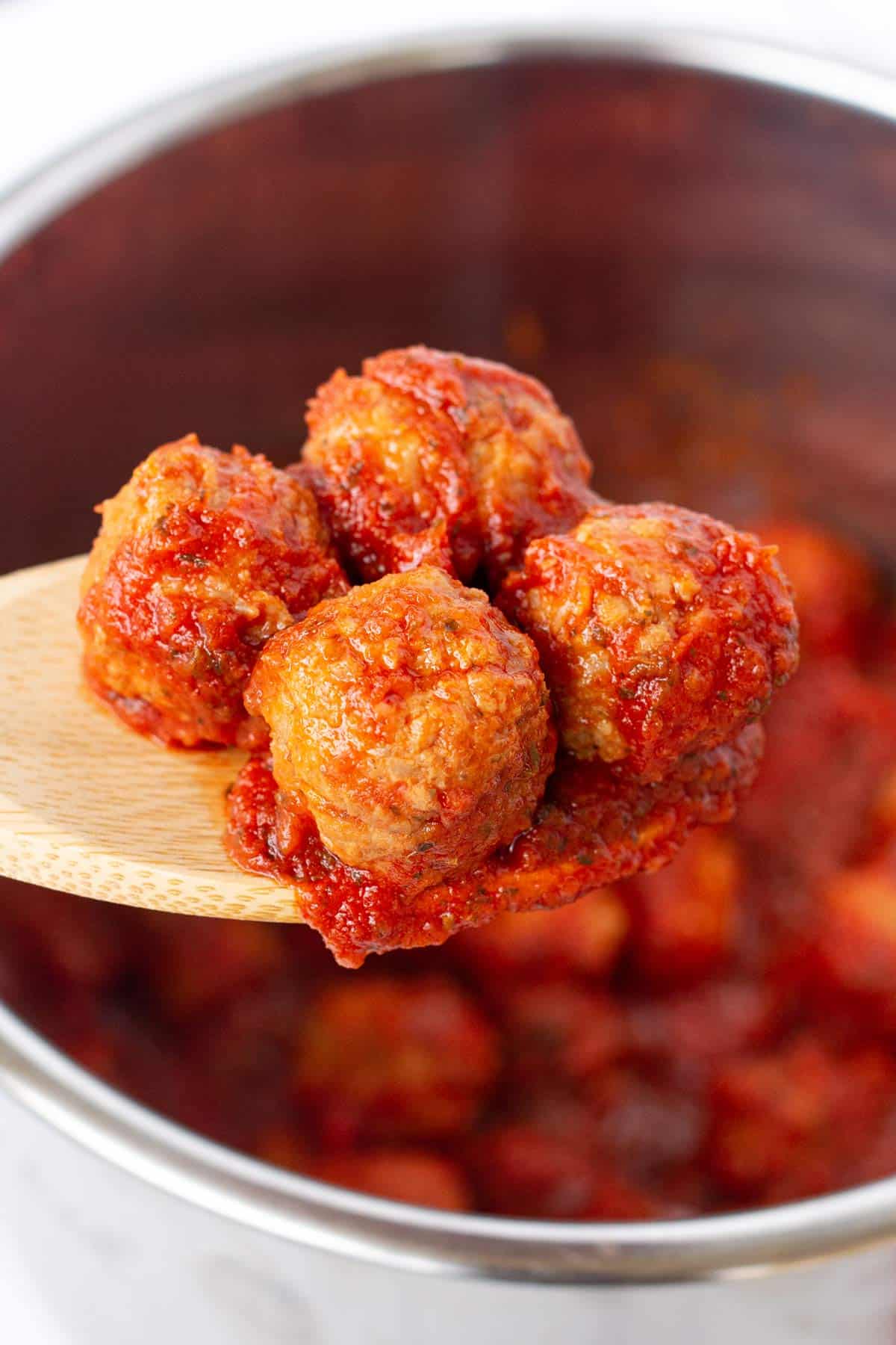 Instant Pot Italian Meatballs on a wooden spoon.