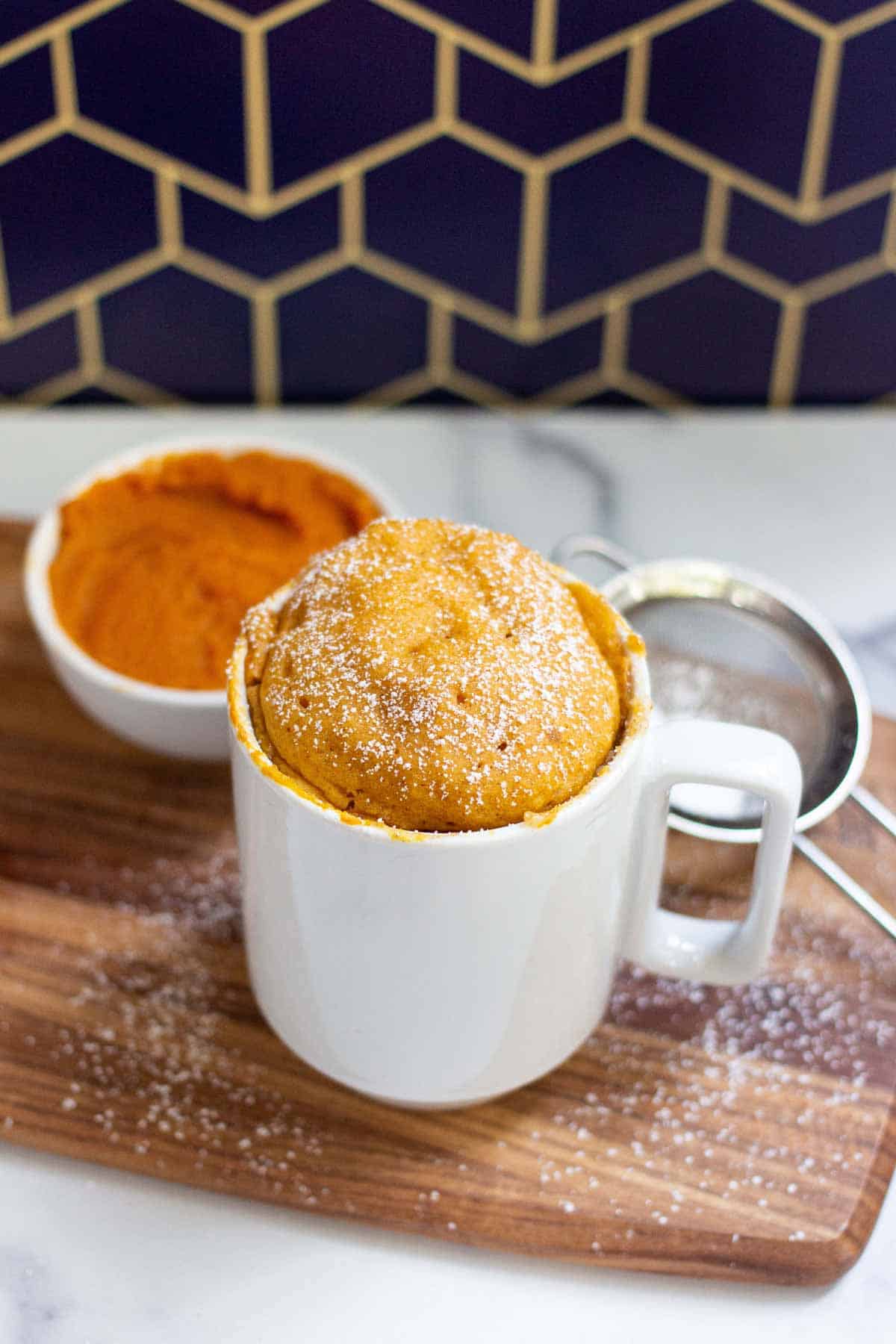 Pumpkin Spice Mug Cake dusted with light layer of powdered sugar.