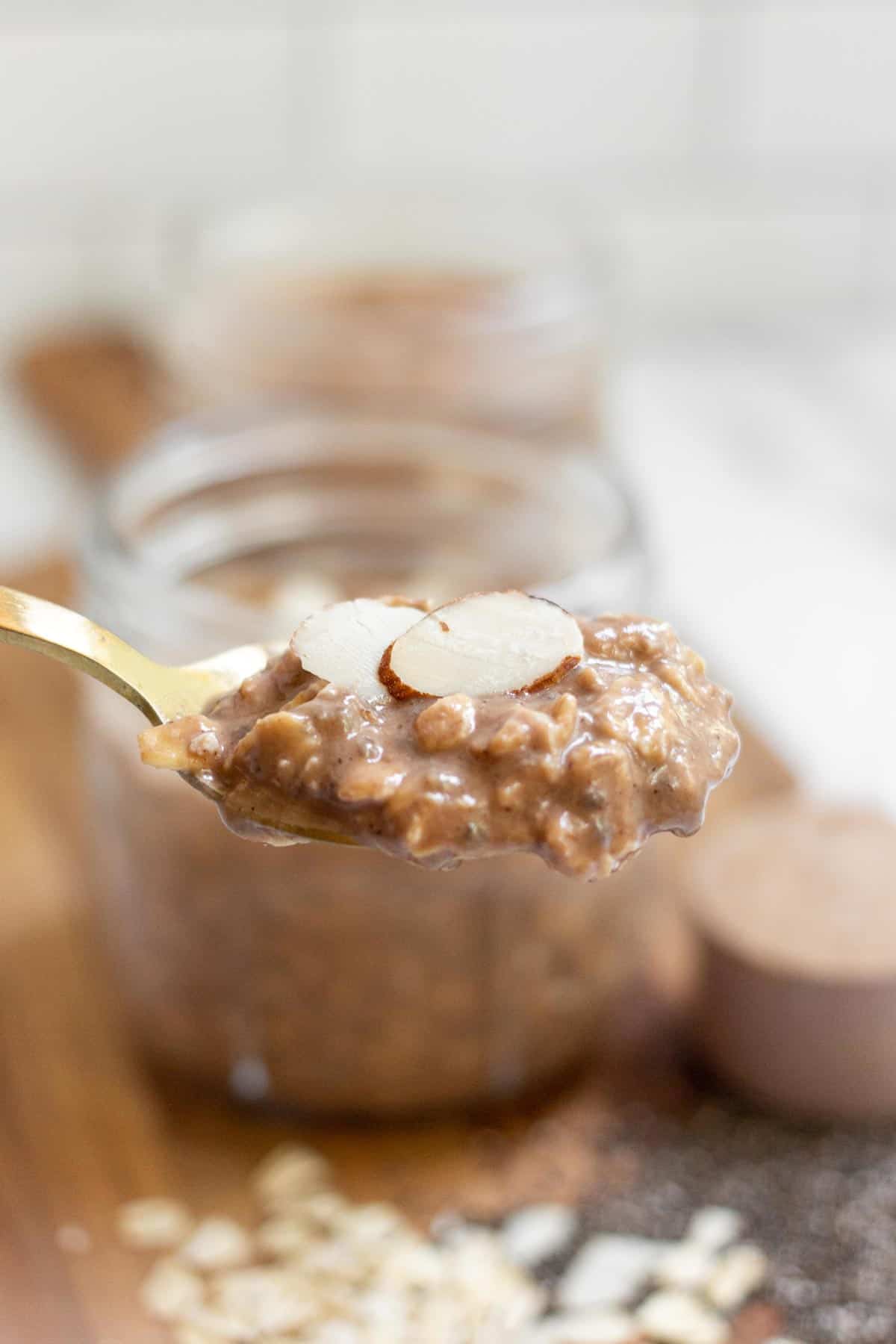 A spoonful of overnight oats with protein powder topped with almond slices.