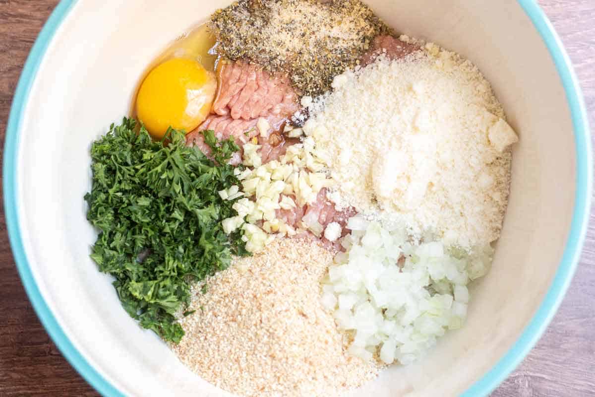 Lean ground turkey, bread crumbs, minced onion, grated parmesan, fresh parsley, egg, minced garlic, Worcestershire sauce, salt, ground black pepper, dried basil, and dried oregano in a large mixing bowl.