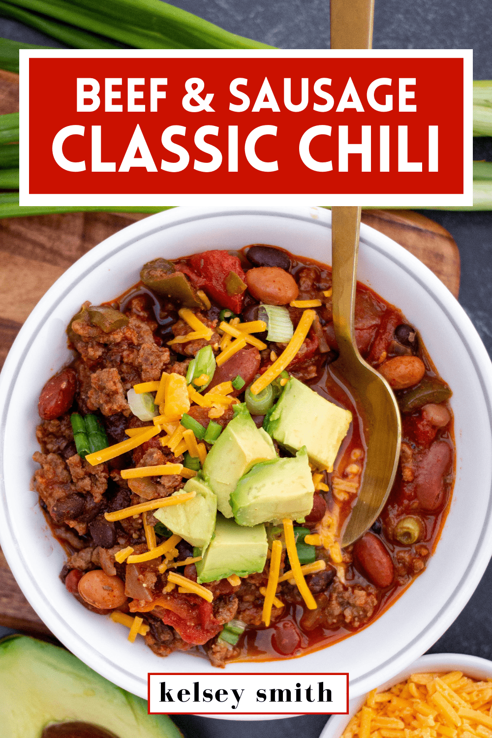 Small bowl of ground beef and sausage chili with shredded cheddar and diced avocado on top. Text at the top says Beef & Sausage Classic Chili.