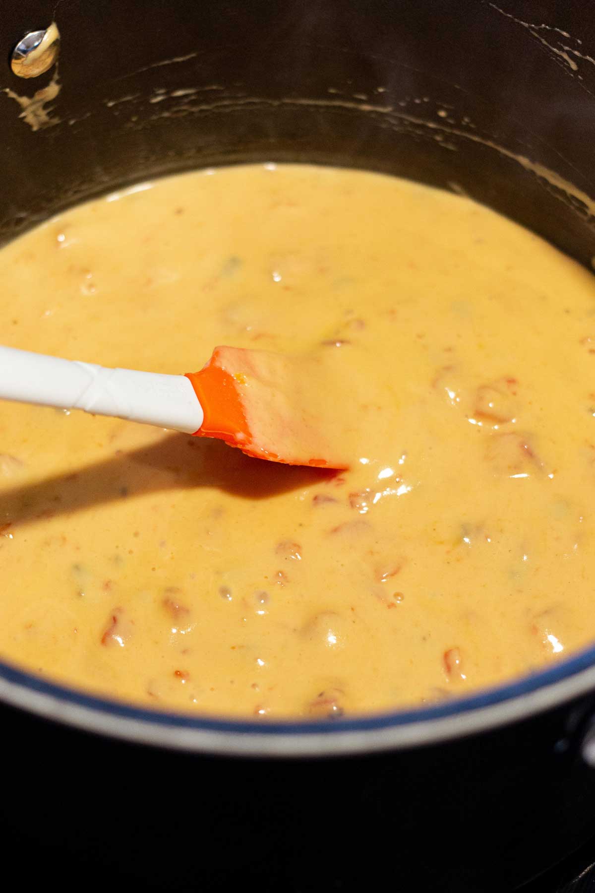 Rotel Velveeta creamy cheese mixture melted in a large pot.