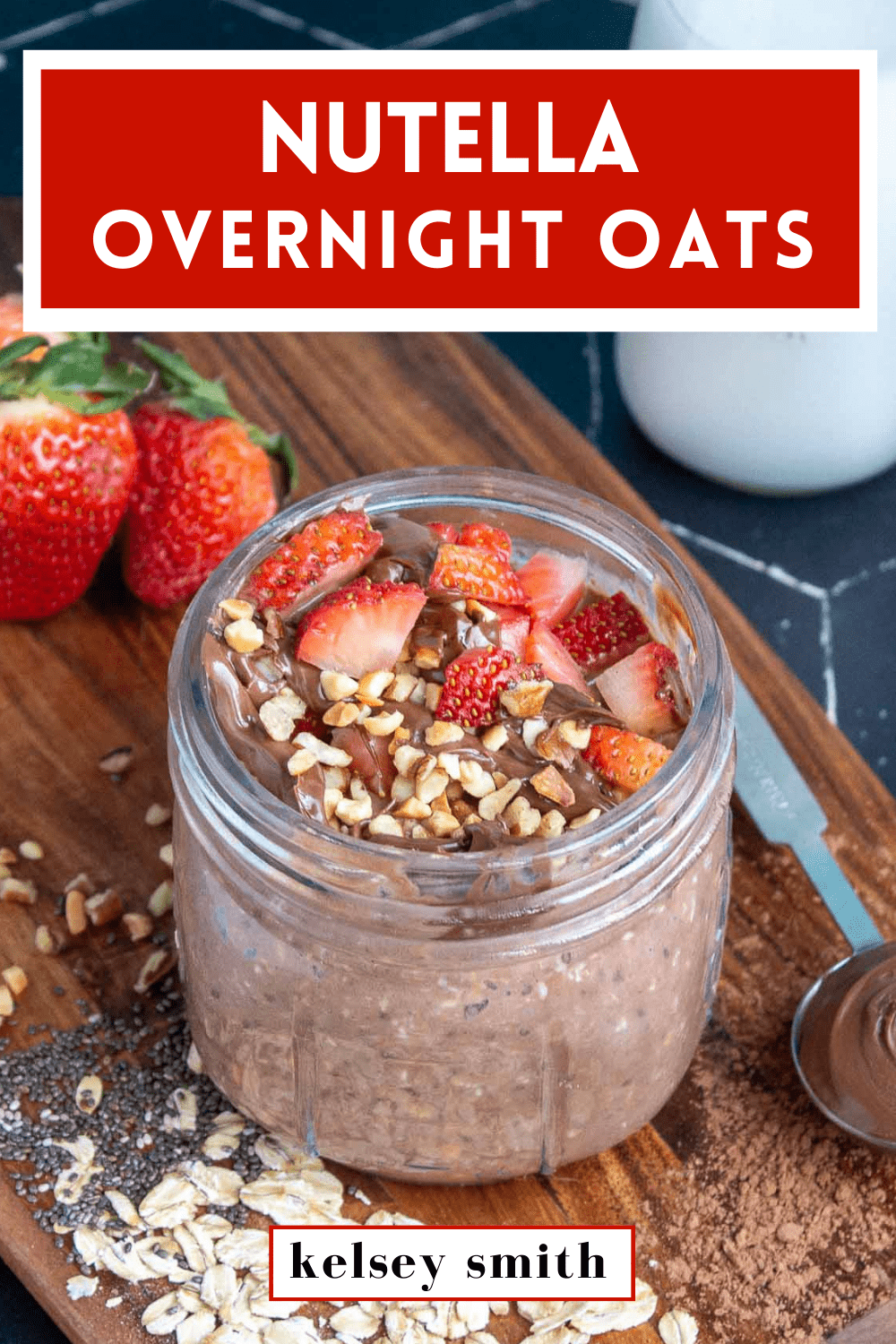 Nutella overnight oats in a mason jar topped with strawberries, Nutella, and hazelnuts. Text at the top of the image says Nutella Overnight Oats.