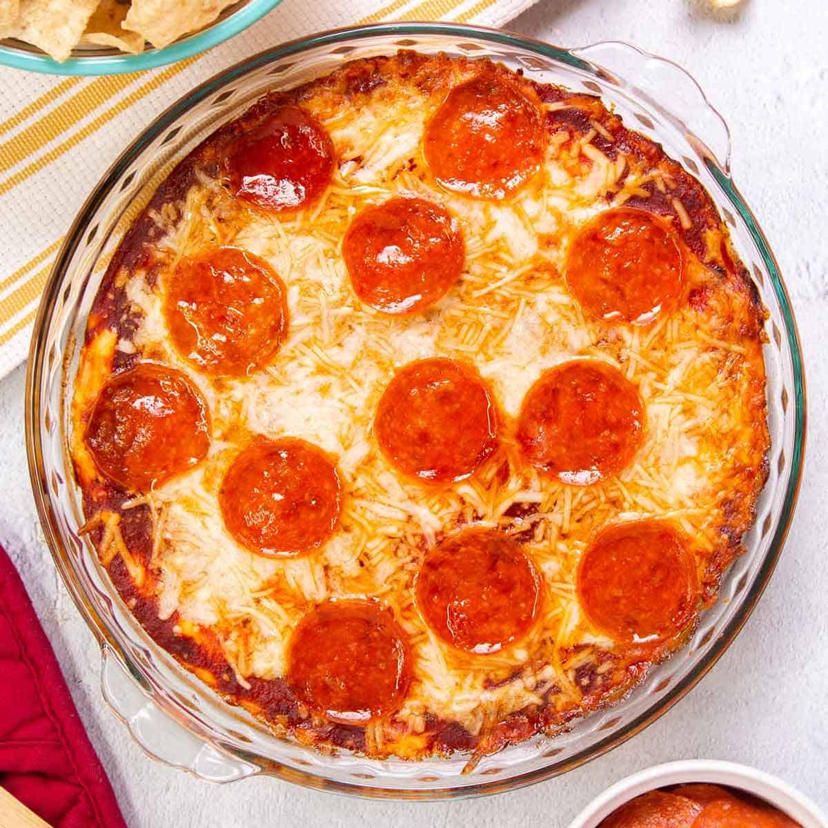Top down view of pizza dip baked in a pie plate. The dip is topped with pepperoni.