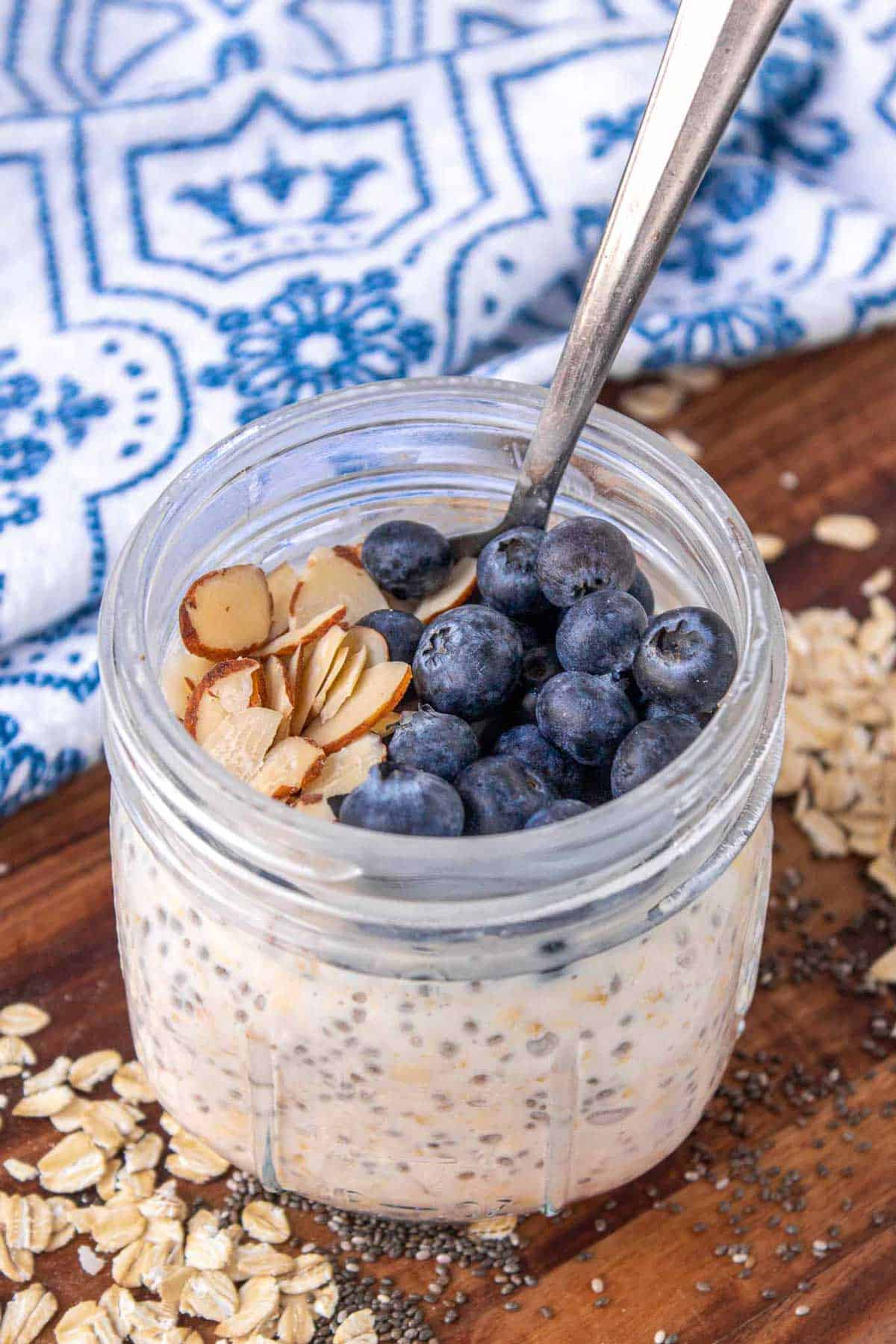 vanilla overnight oats in a 12 ounce Mason jar topped with blueberries and sliced almonds.