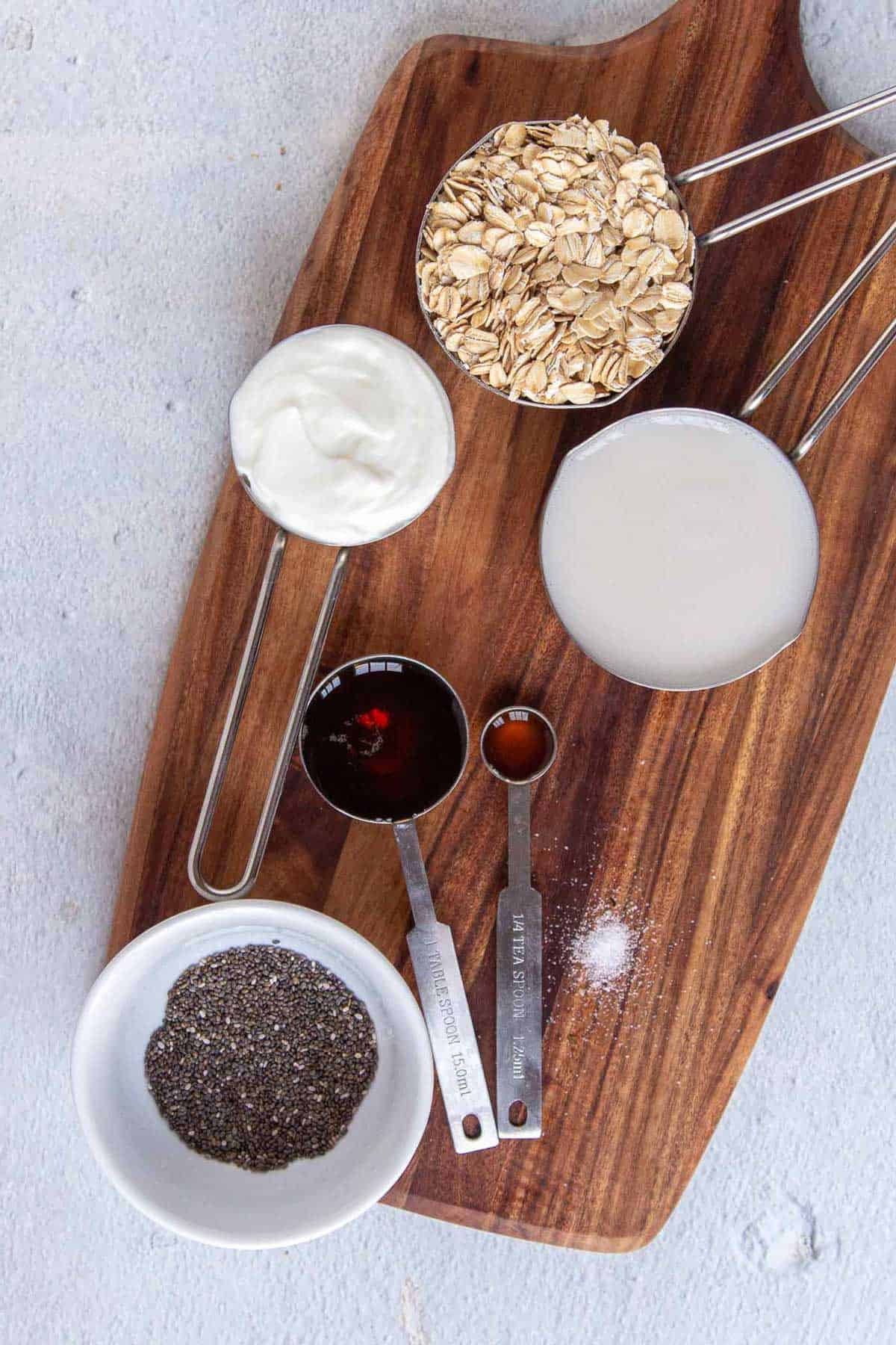 Vanilla overnight oats ingredients: old fashioned oats, milk, yogurt, chia seeds, maple syrup, vanilla, and salt.