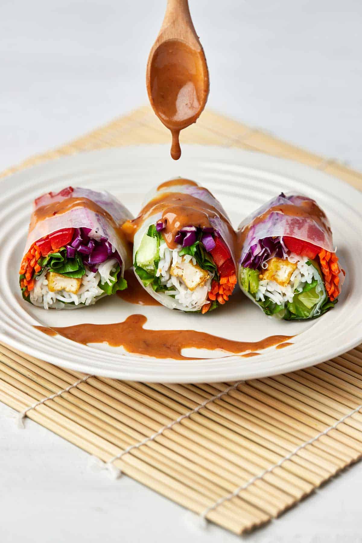Spring rolls drizzled in peanut sauce.