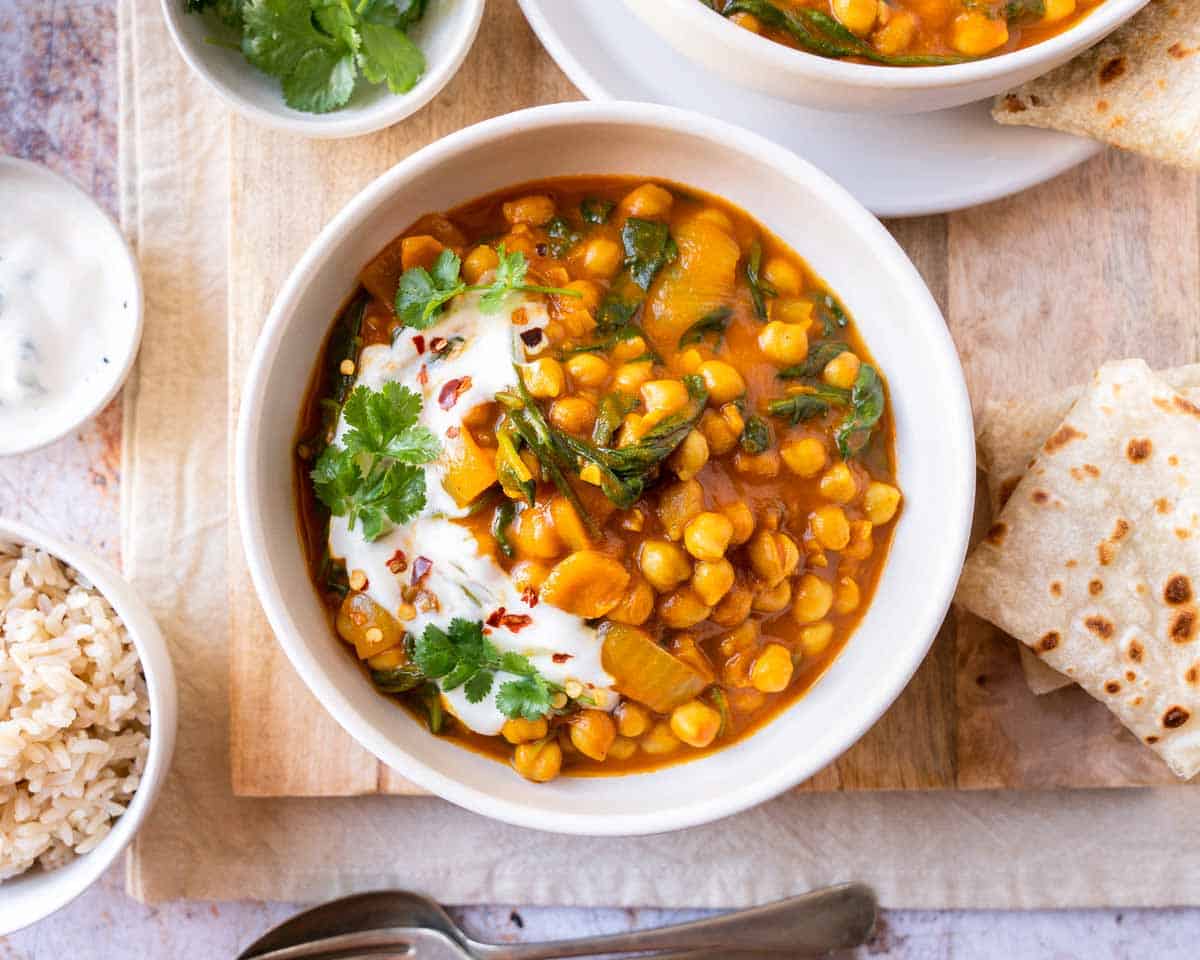 Chickpea and spinach curry garnished with fresh cilantro and yogurt.