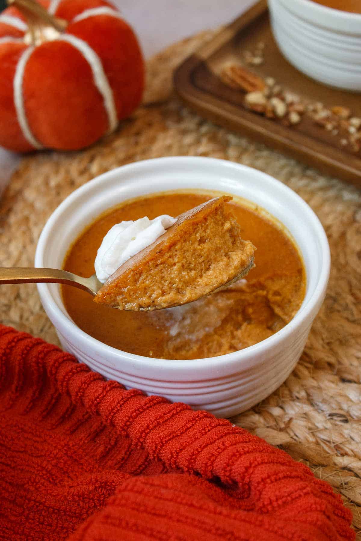 Spoonful of baked pumpkin custard shows creamy texture.