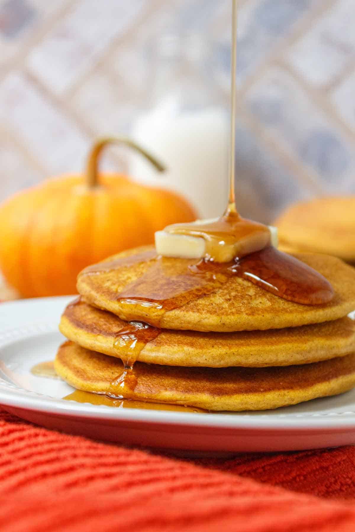 Maple syrup poured over Bisquick pumpkin pancakes.