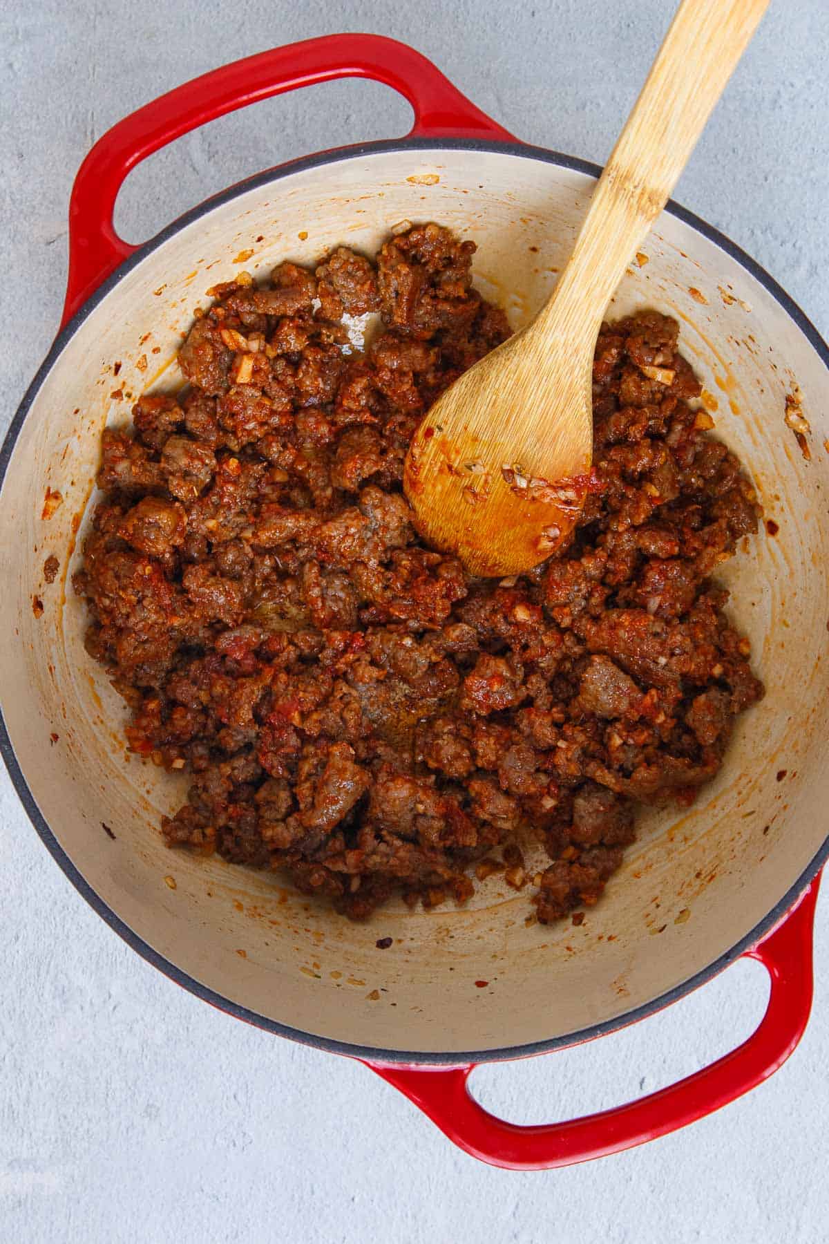 Tomato paste mixed in with cooked Italian sausage