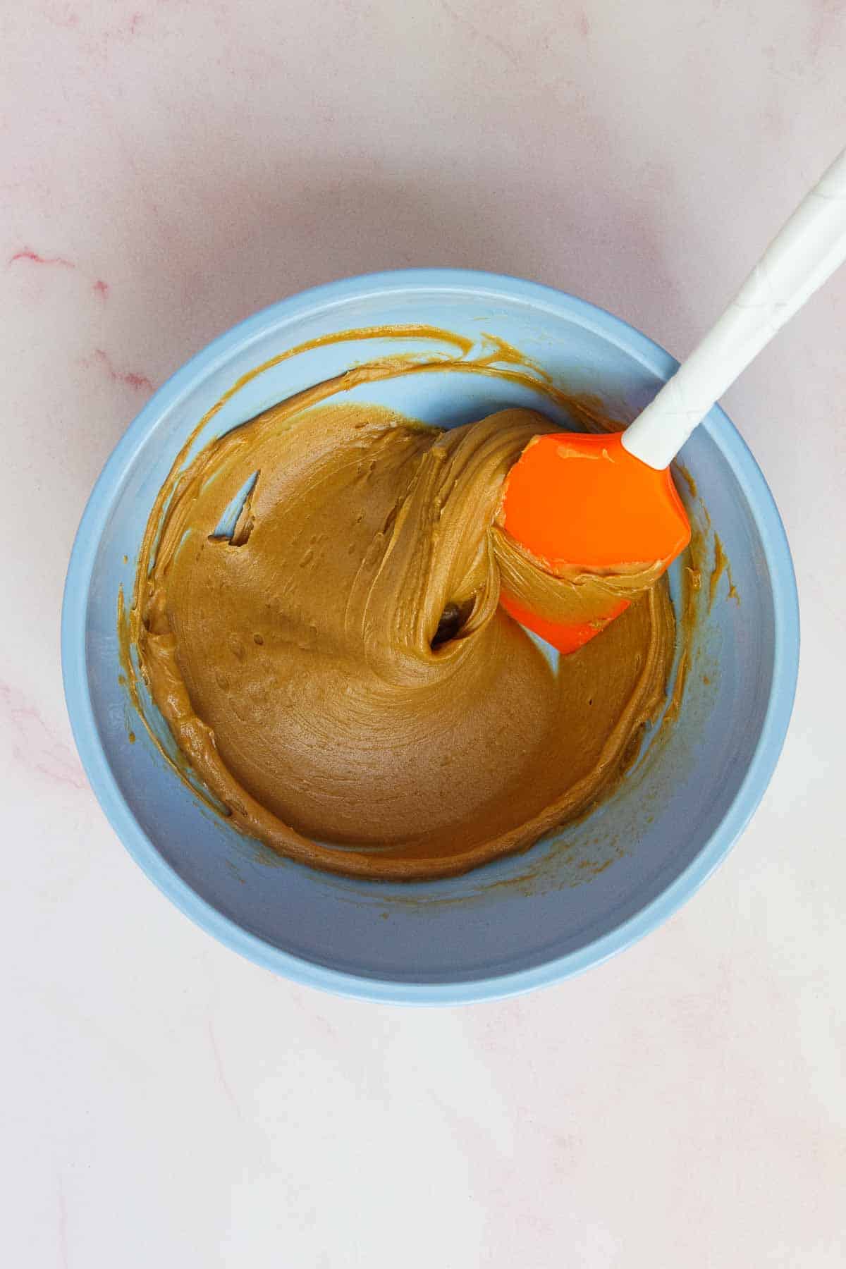 Peanut butter and maple syrup mixed together in a medium mixing bowl