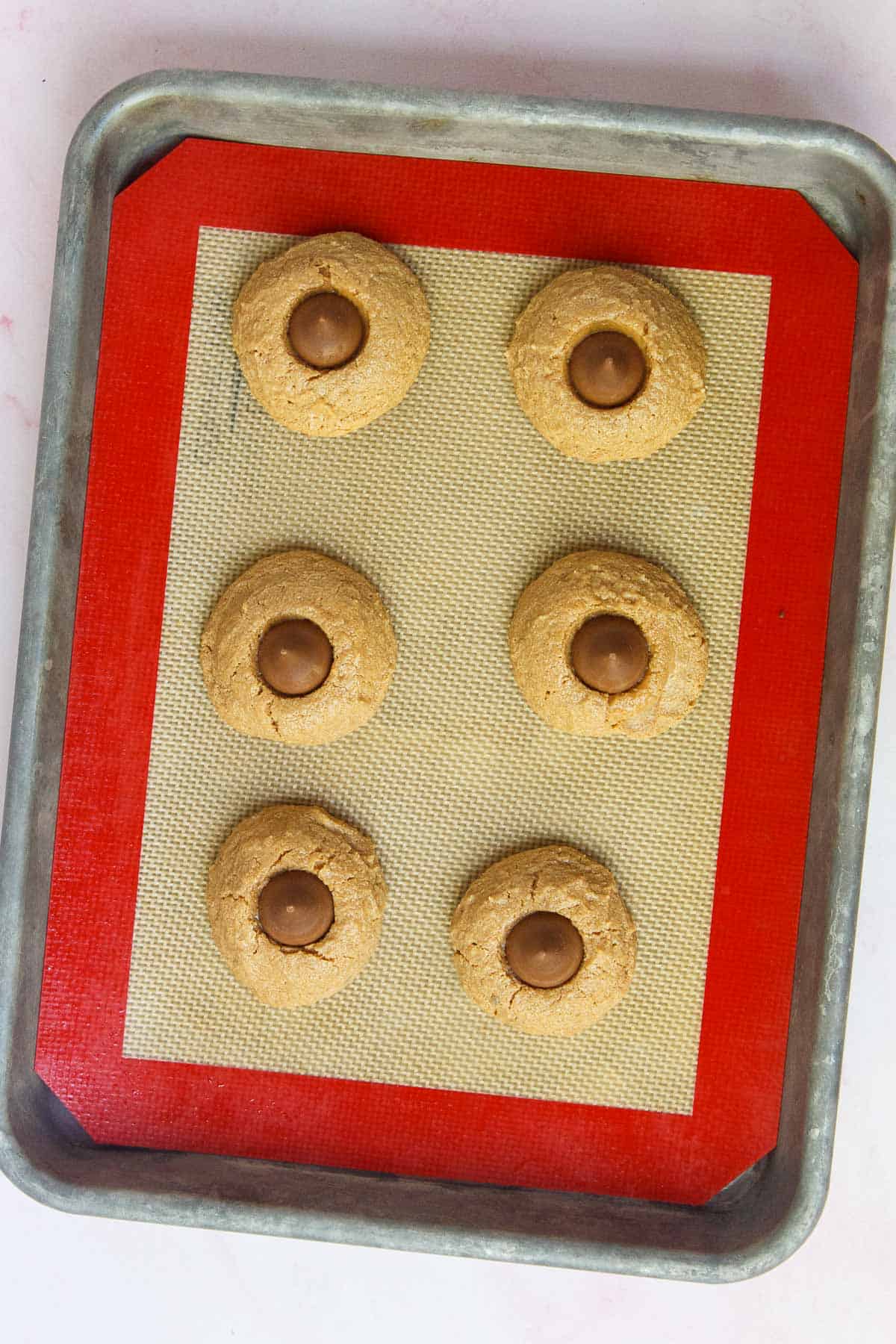 Baked peanut butter cookies with a Hershey Kiss pressed into the center of each cookie