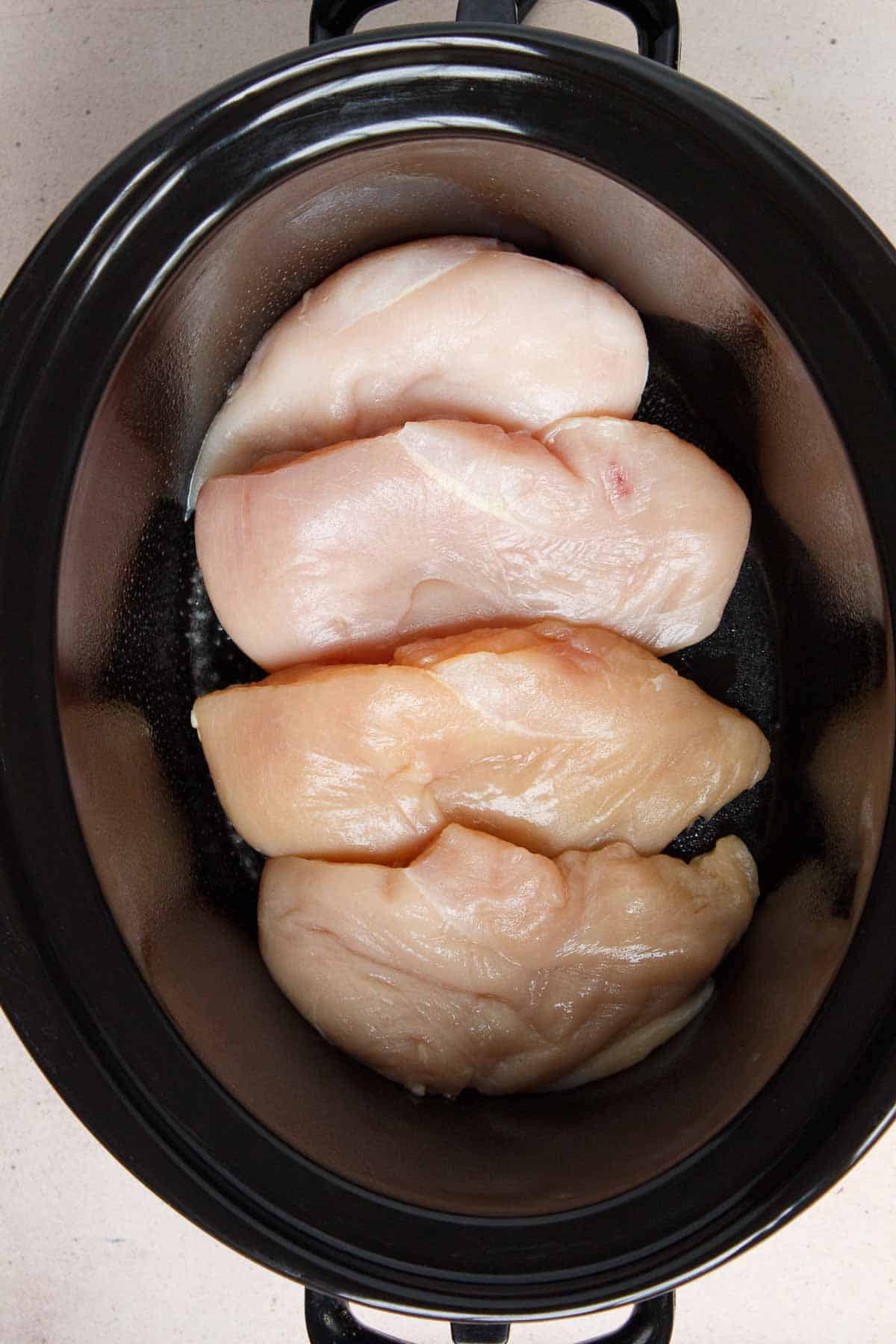 Four chicken breasts in the bottom of the slow cooker