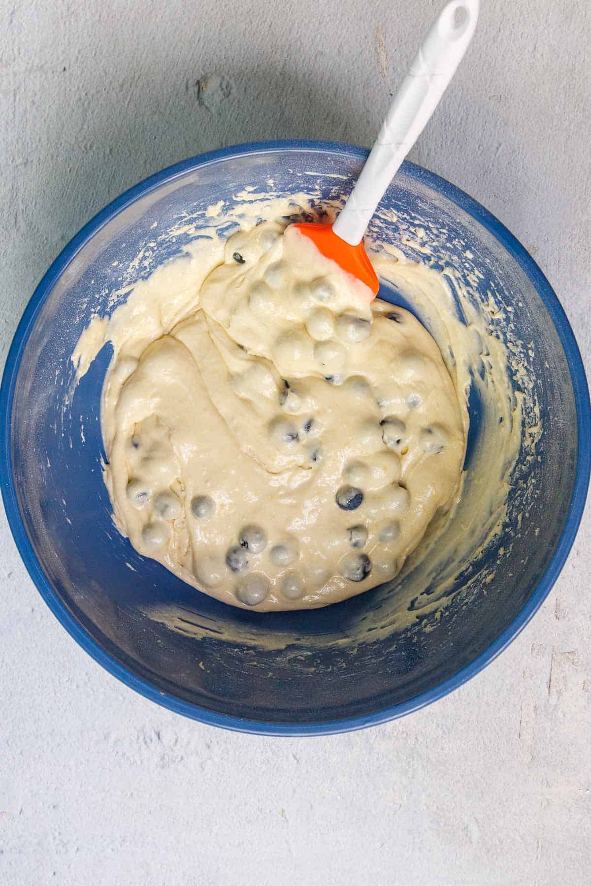Cake mix blueberry muffin batter in a large mixing bowl with the blueberries folded in