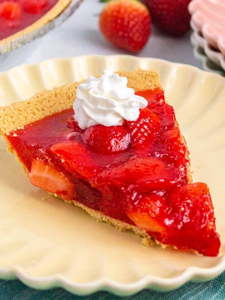 Slice of strawberry jello pie with a dollop of whipped topping