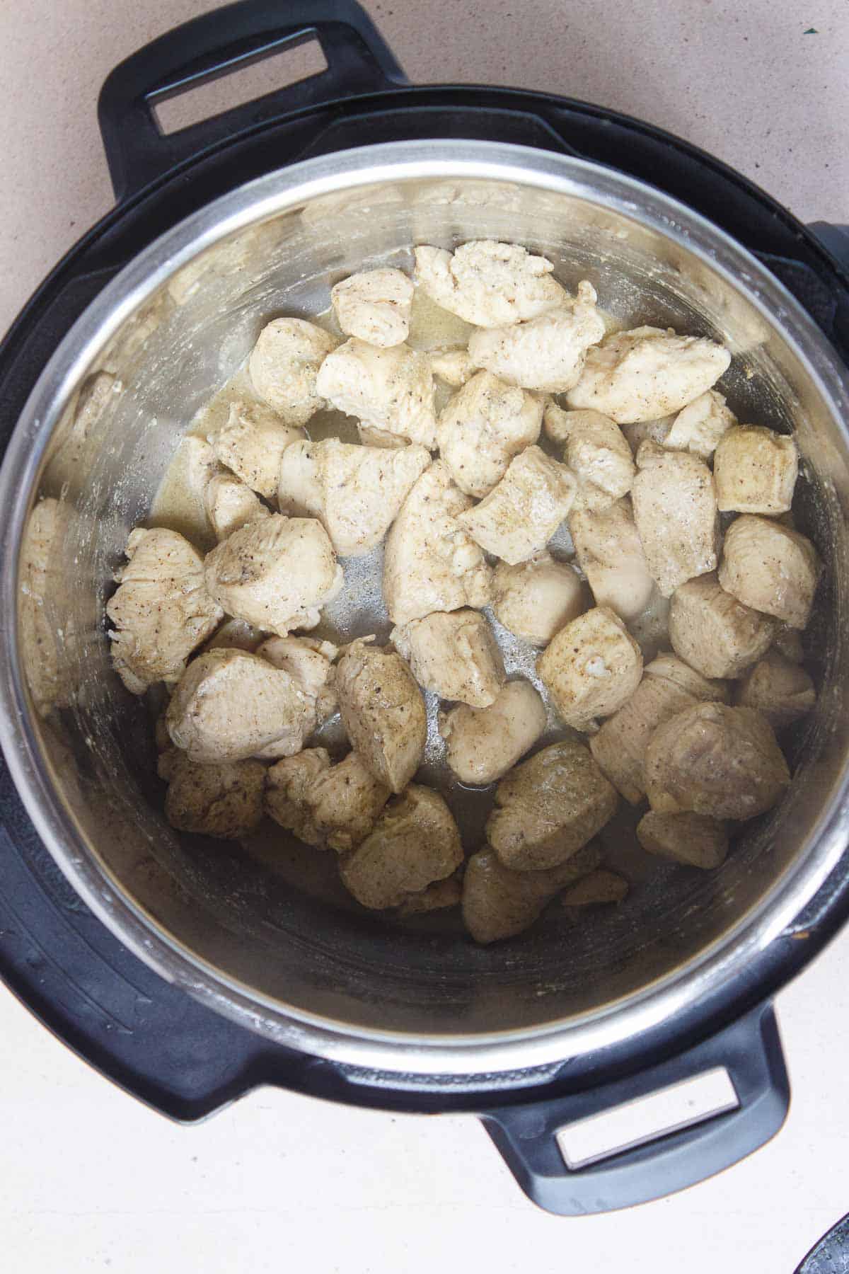 Diced chicken that has been browned in the Instant Pot