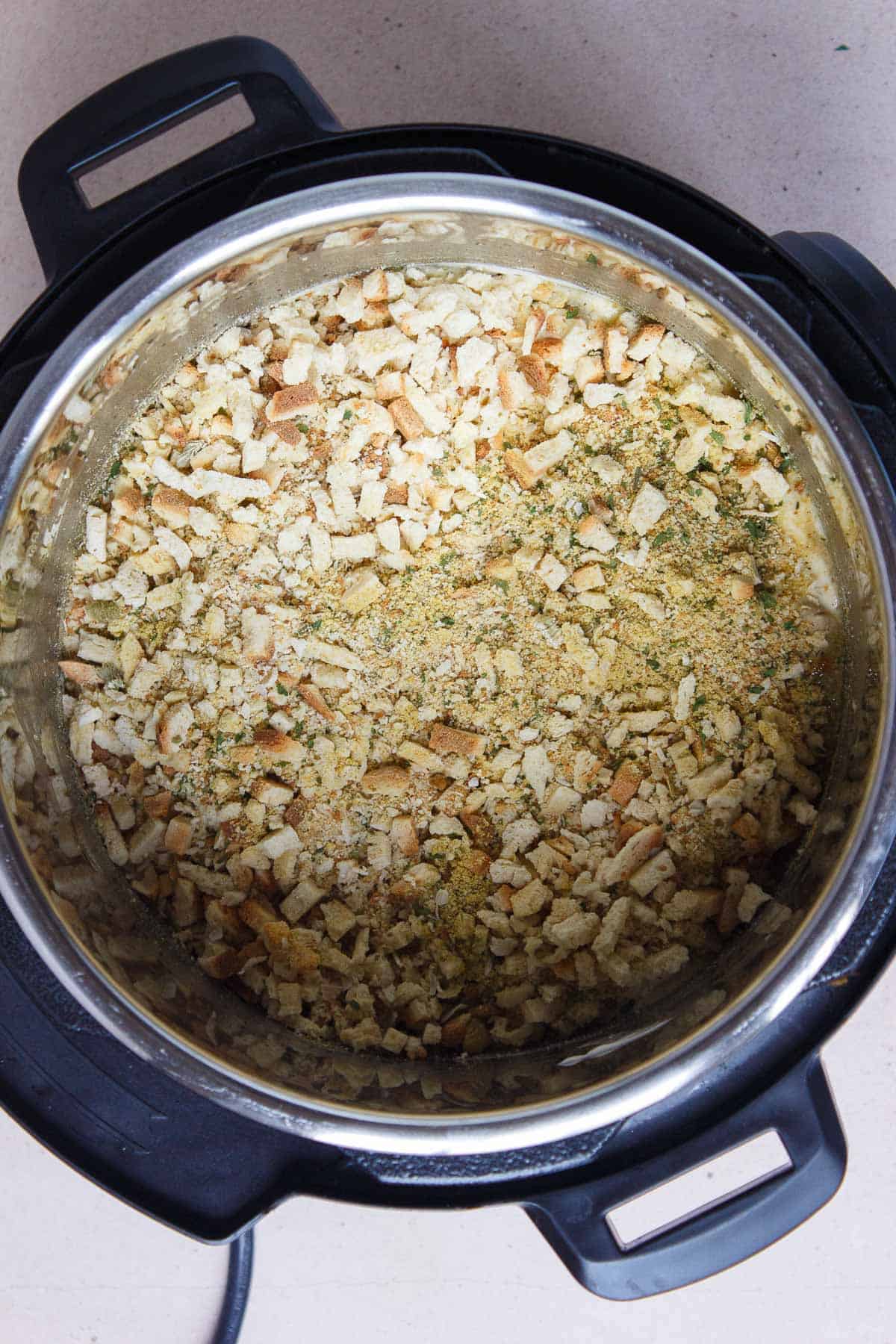 Stuffing sprinkled evenly over the top of the soup layer in the Instant Pot