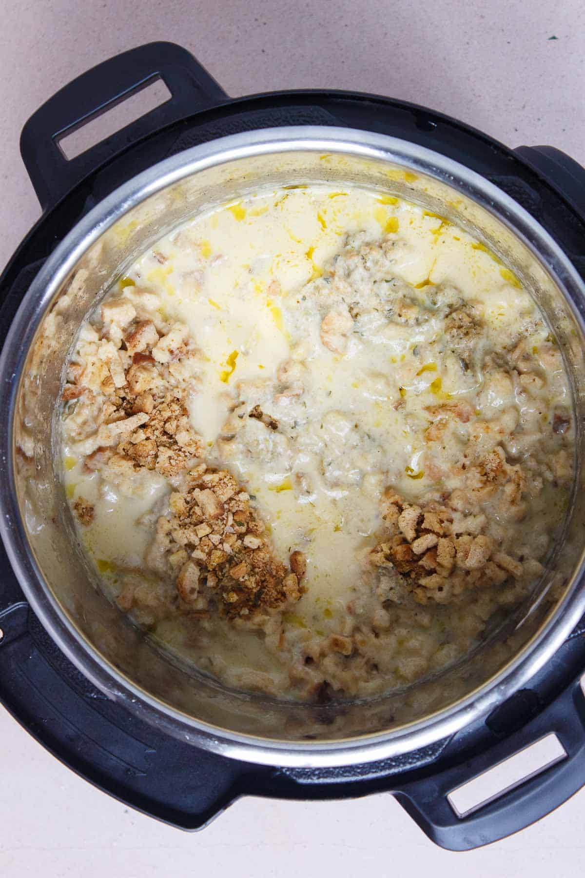 Instant Pot Chicken Stuffing Casserole after a quick release of pressure. Most of the stuffing is submerged in liquid with some dry mix remaining.