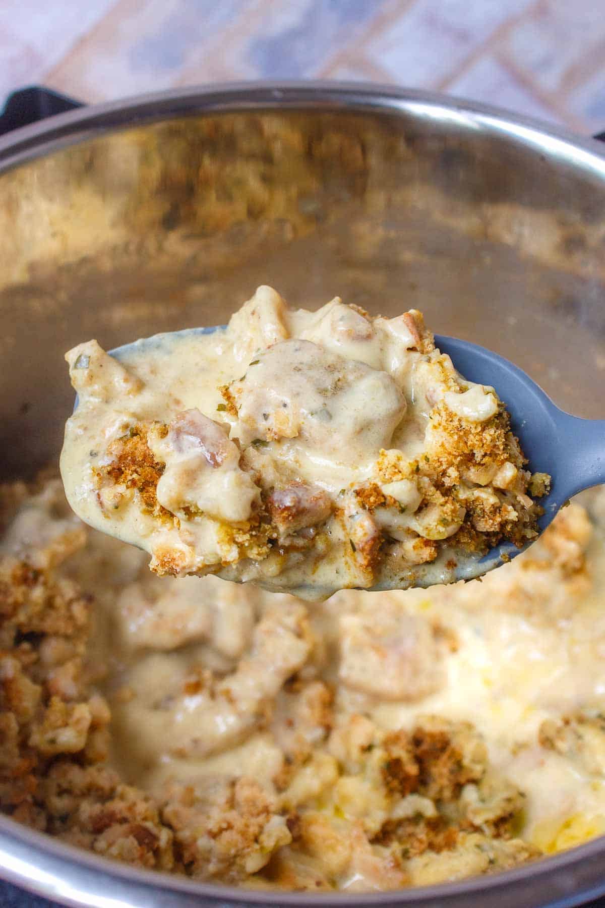 Large serving spoon filled with Instant Pot Chicken Stuffing Casserole