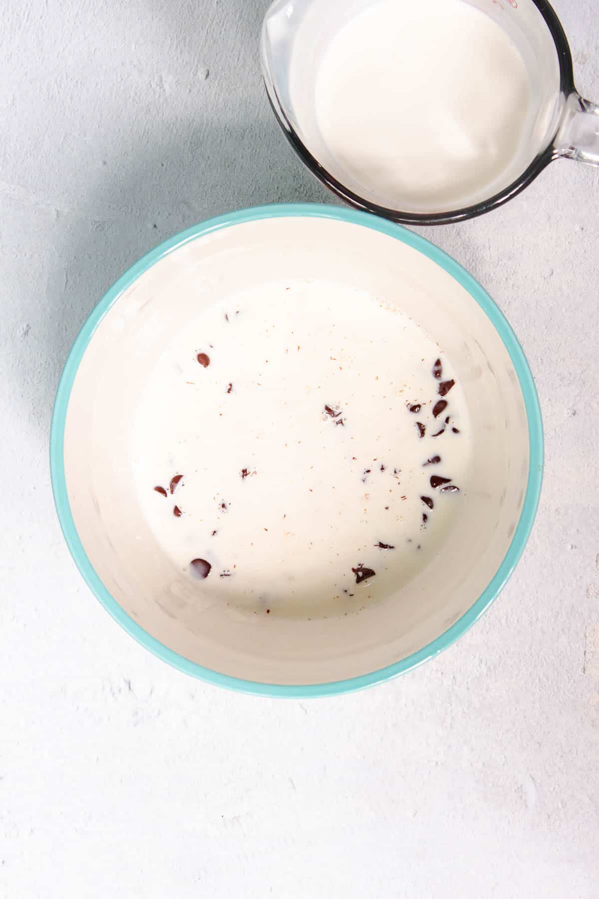 Chocolate chips are submerged in warm heavy cream