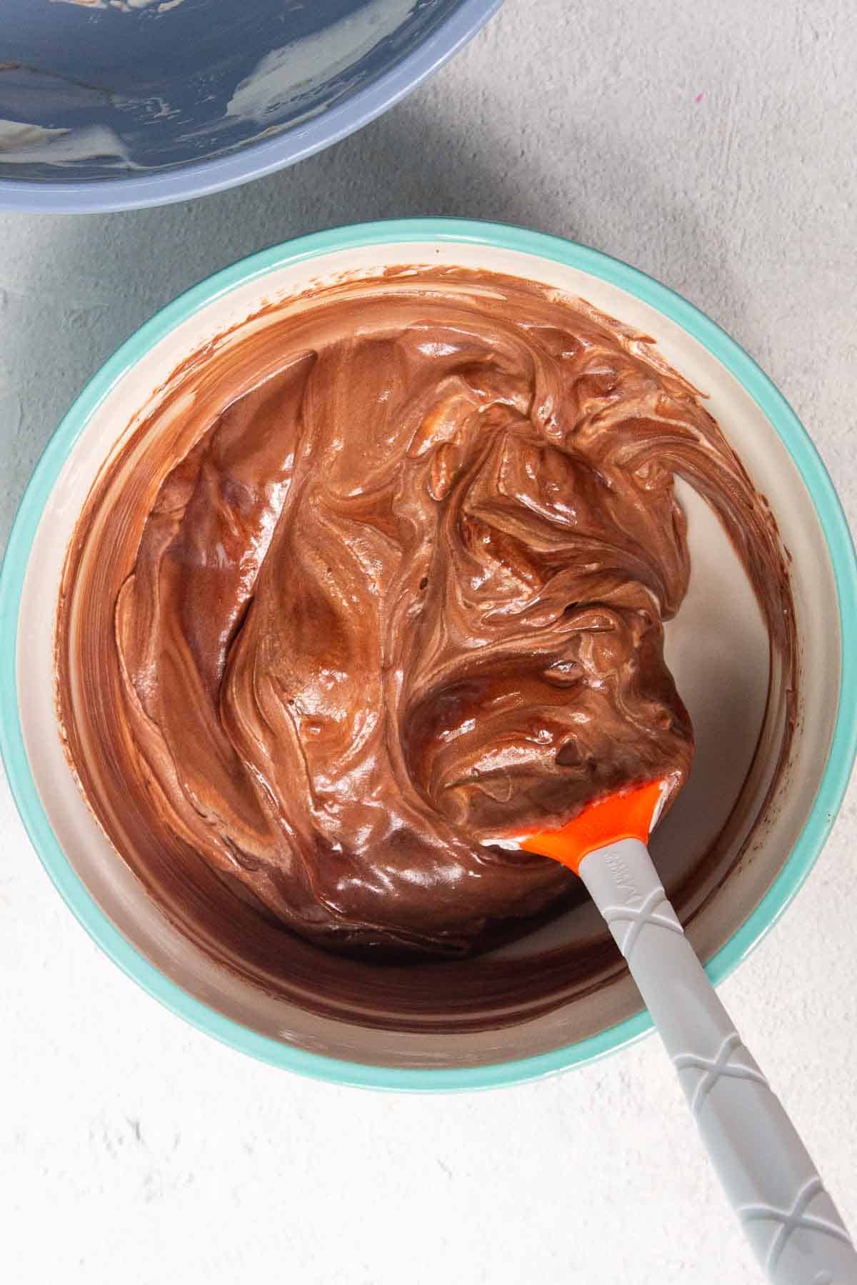 The chocolate mousse mixture is mostly combined with some faint streaks of cream remaining