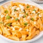 Buffalo Chicken Pasta garnished with cheese crumbles and green onion