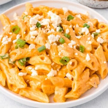 Buffalo Chicken Pasta garnished with cheese crumbles and green onion