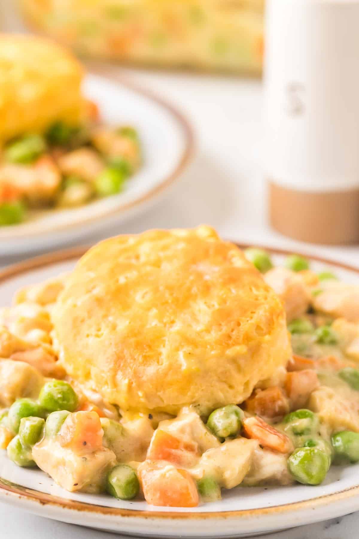 Dinner plate of chicken pot pie casserole with a biscuit on top