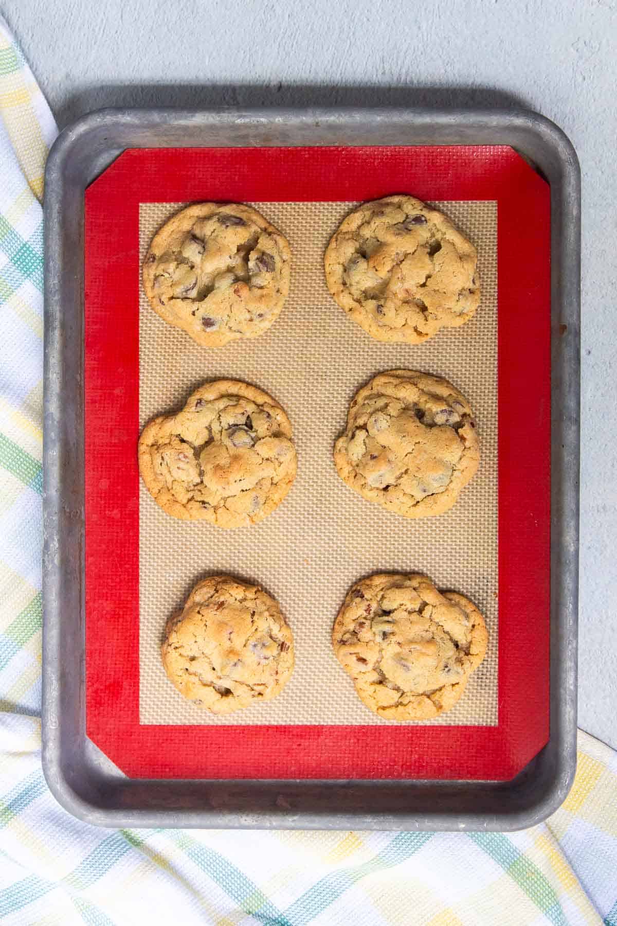 Crisco Ultimate Chocolate Chip Cookies baked on a baking sheet with a silicone baking mat